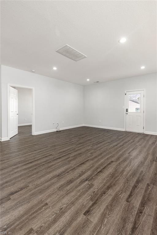 spare room with visible vents, recessed lighting, baseboards, and dark wood-style flooring