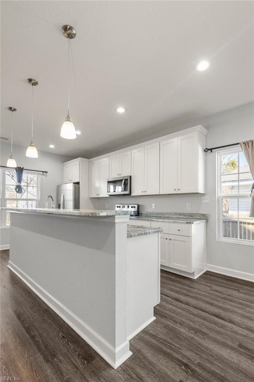 kitchen featuring dark wood finished floors, white cabinets, baseboards, and appliances with stainless steel finishes