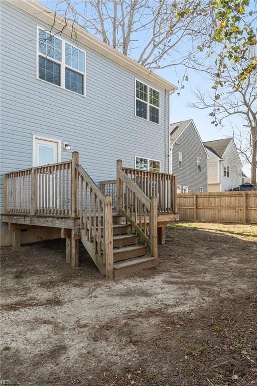 back of property with a deck and fence