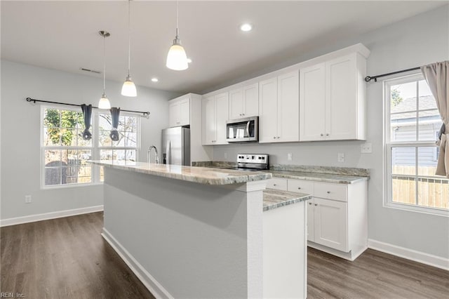 kitchen with white cabinets, a kitchen island with sink, dark wood-style flooring, and stainless steel appliances