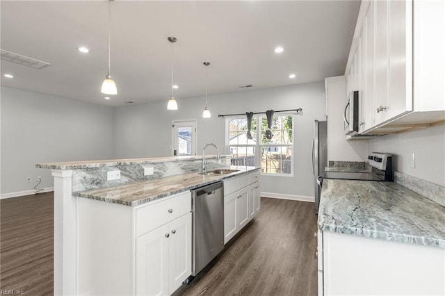 kitchen featuring a sink, dark wood-style flooring, stainless steel appliances, white cabinetry, and a kitchen island with sink