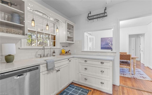 kitchen featuring a sink, backsplash, dishwasher, light wood-style floors, and open shelves