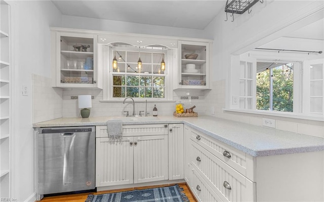 kitchen featuring a sink, open shelves, dishwasher, and decorative backsplash