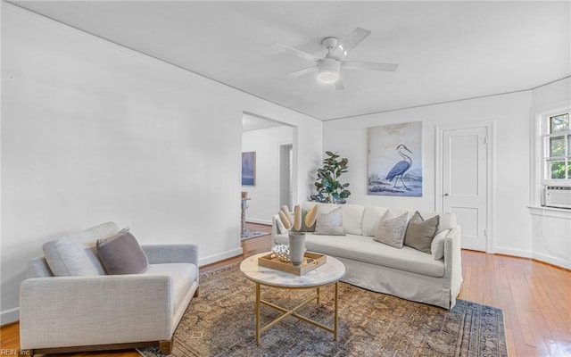 living area featuring cooling unit, baseboards, ceiling fan, and hardwood / wood-style floors