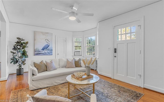 living area with light wood finished floors, ceiling fan, and baseboards