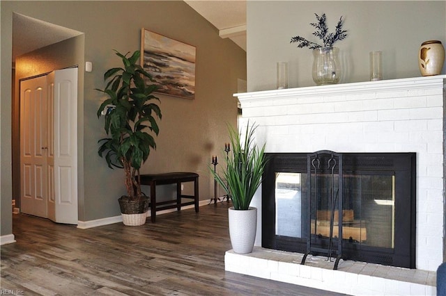 room details featuring wood finished floors, beamed ceiling, a fireplace, and baseboards