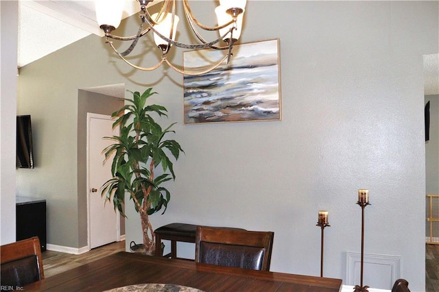 dining area with a chandelier, baseboards, and wood finished floors