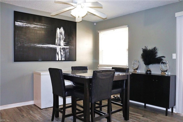 dining room featuring a ceiling fan, wood finished floors, and baseboards