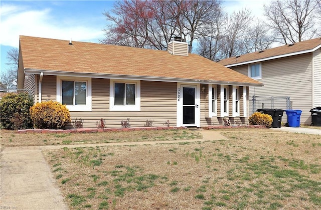 view of front of house featuring a chimney and a front yard