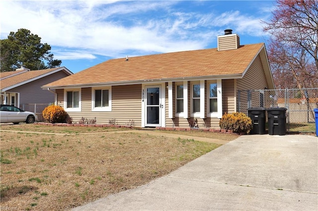 ranch-style house featuring a chimney, a shingled roof, a front lawn, and fence