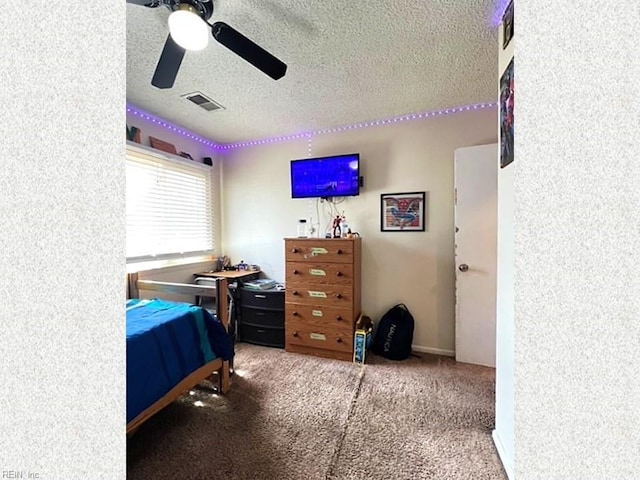 carpeted bedroom featuring visible vents, a textured ceiling, and ceiling fan