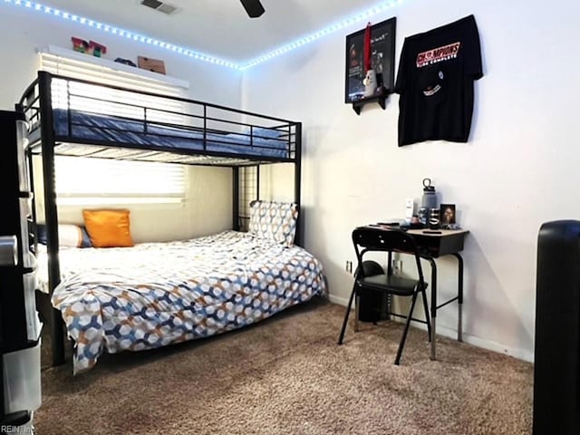 carpeted bedroom with visible vents, ceiling fan, and baseboards