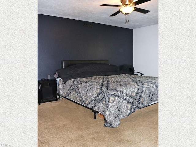 carpeted bedroom featuring a textured ceiling and a ceiling fan