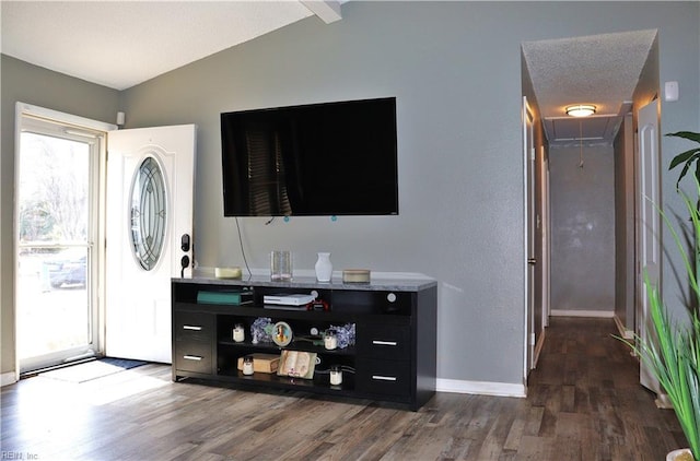 foyer entrance featuring dark wood finished floors, baseboards, and lofted ceiling