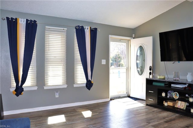 foyer with baseboards, lofted ceiling, a textured ceiling, and wood finished floors