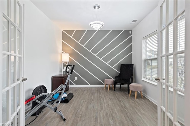 workout area featuring french doors, baseboards, visible vents, and wood finished floors