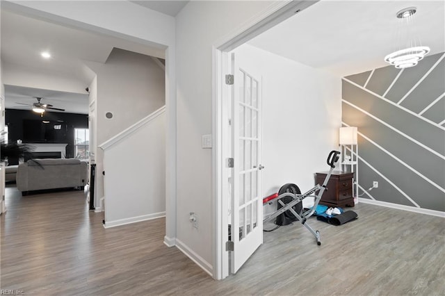 corridor with baseboards and wood finished floors