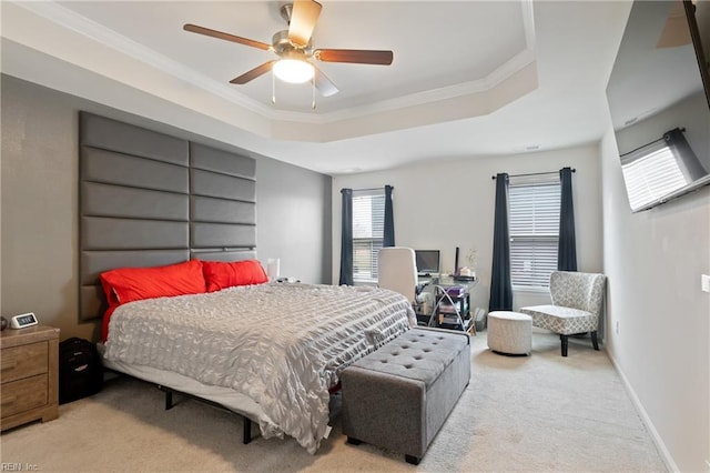 bedroom featuring a raised ceiling, carpet floors, crown molding, baseboards, and ceiling fan