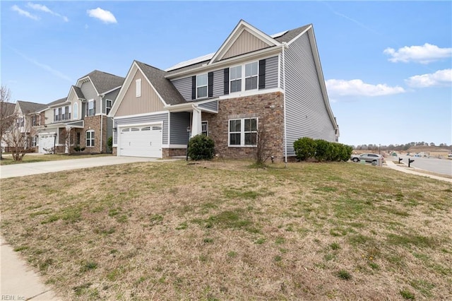 view of front of property featuring a front yard, solar panels, concrete driveway, a garage, and stone siding