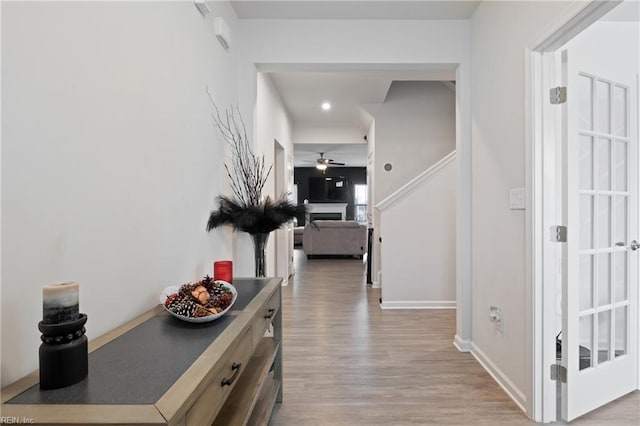 hall featuring baseboards and light wood finished floors