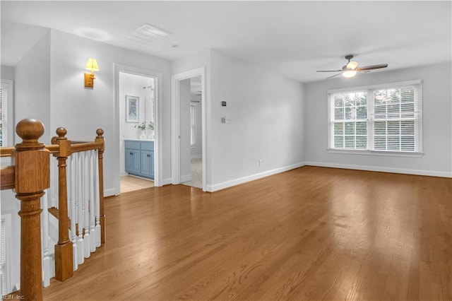 unfurnished living room with light wood finished floors, ceiling fan, and baseboards