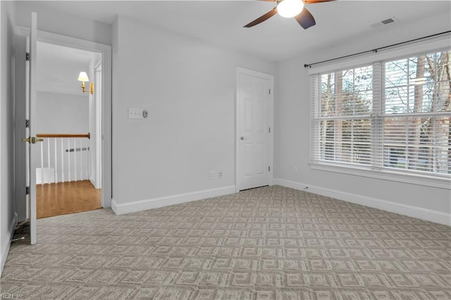 empty room with visible vents, baseboards, and light carpet