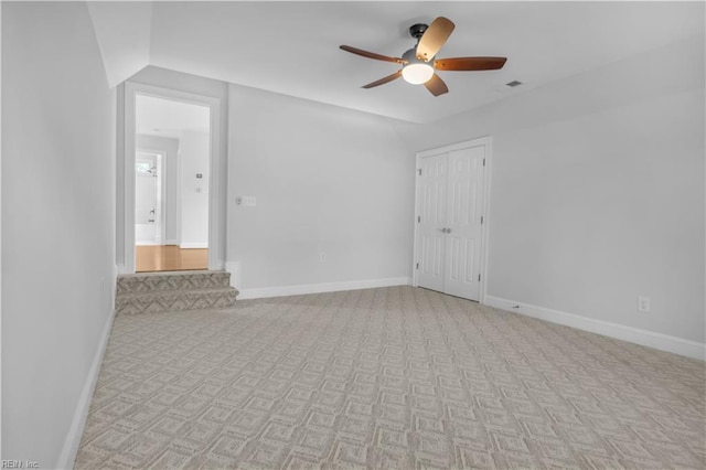 unfurnished room featuring visible vents, baseboards, light carpet, and a ceiling fan