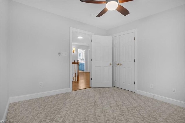 empty room with ceiling fan, baseboards, and light carpet