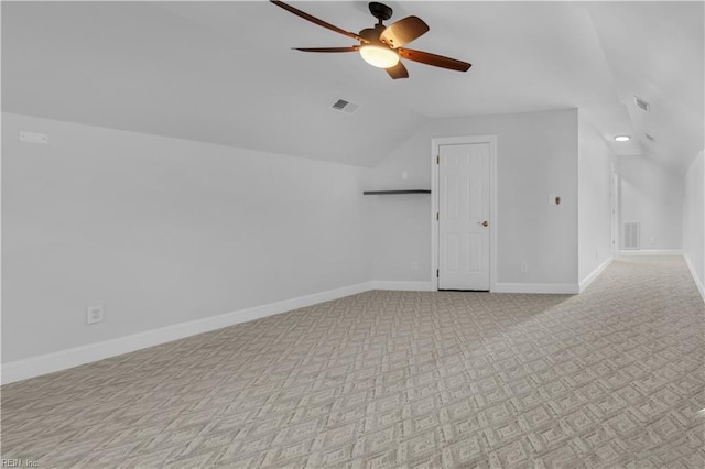 additional living space featuring visible vents, lofted ceiling, baseboards, and a ceiling fan