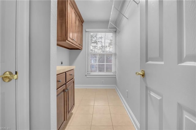 interior space featuring light tile patterned floors, baseboards, and electric dryer hookup