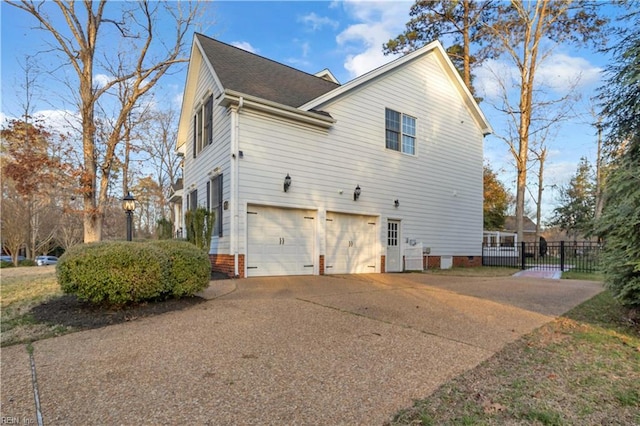 view of side of property with fence, roof with shingles, driveway, an attached garage, and crawl space