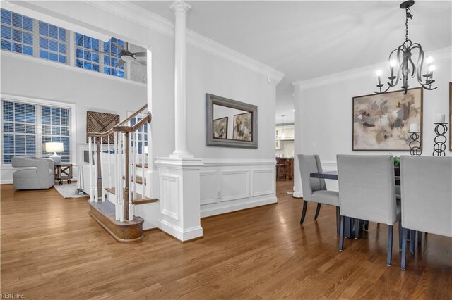 dining space featuring crown molding, stairway, and wood finished floors