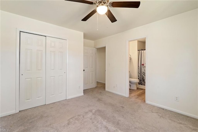 unfurnished bedroom with ensuite bathroom, a closet, carpet flooring, baseboards, and ceiling fan