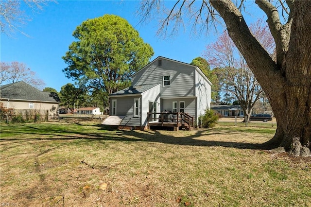 back of house featuring a wooden deck and a yard