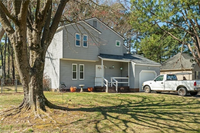 view of front facade featuring a front yard, an attached garage, and fence