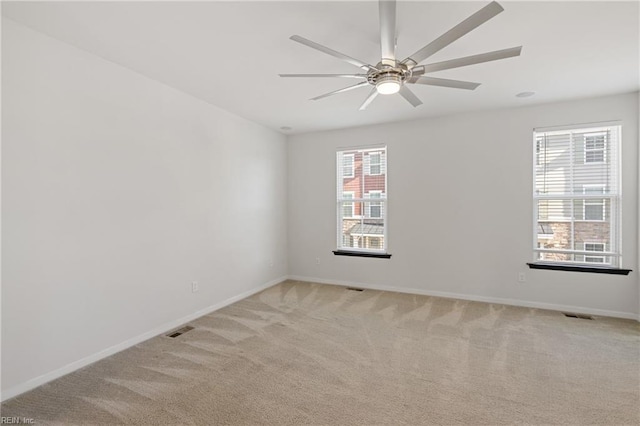 empty room with visible vents, baseboards, and light colored carpet