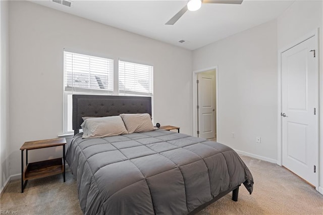 bedroom featuring visible vents, light colored carpet, a ceiling fan, and baseboards