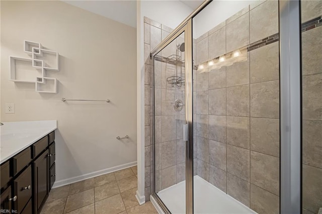 bathroom featuring tile patterned flooring, a stall shower, vanity, and baseboards