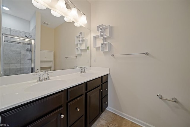 full bathroom featuring a sink, a shower stall, double vanity, and tile patterned flooring