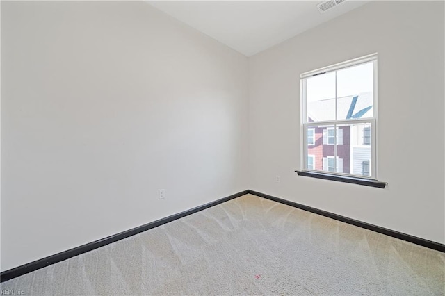 carpeted empty room featuring visible vents and baseboards