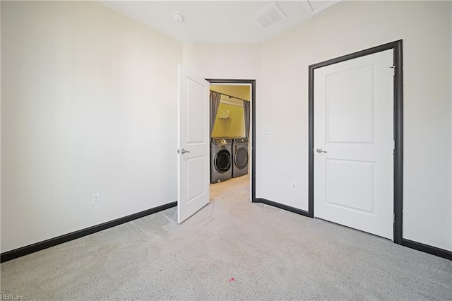 unfurnished bedroom with washer and clothes dryer, carpet flooring, baseboards, and visible vents