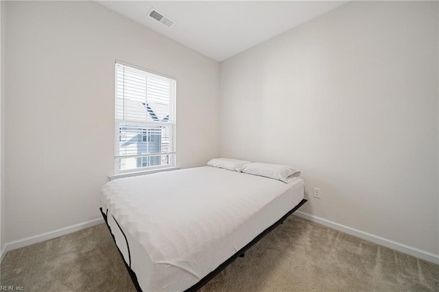 carpeted bedroom with visible vents and baseboards