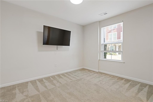 empty room featuring baseboards, visible vents, and carpet floors