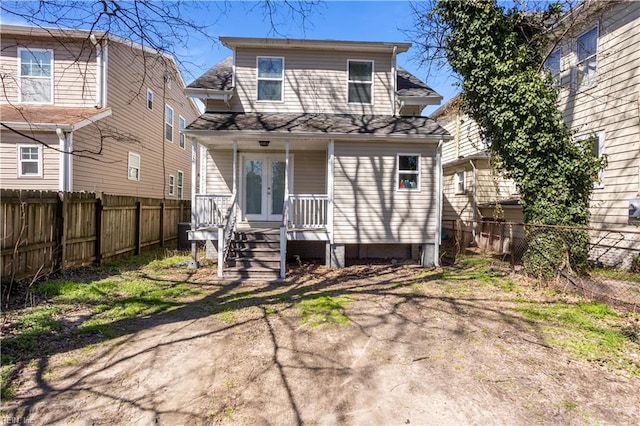 back of property with french doors, a porch, and a fenced backyard