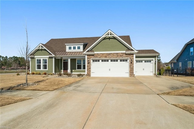 craftsman-style home featuring driveway, a standing seam roof, stone siding, fence, and a garage