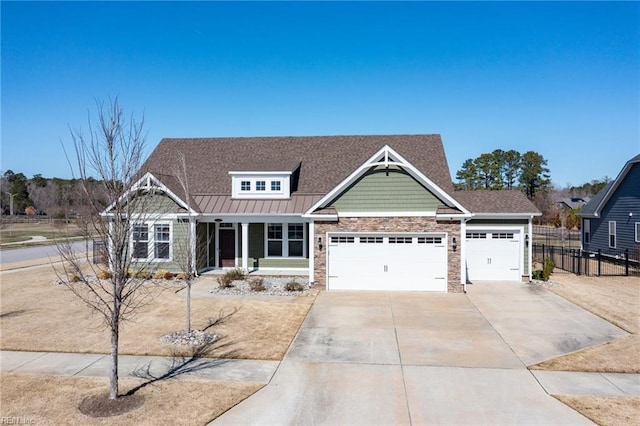 craftsman-style house featuring fence, driveway, a standing seam roof, a garage, and metal roof