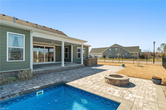 view of pool featuring a fenced in pool, ceiling fan, fence, an outdoor fire pit, and a patio area