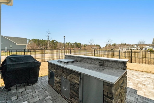 view of patio / terrace featuring area for grilling, exterior kitchen, and a fenced backyard