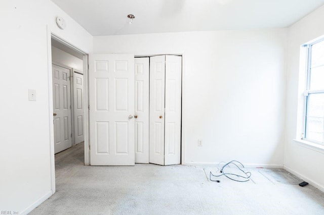 unfurnished bedroom with baseboards and a closet