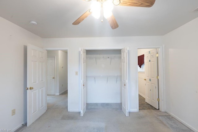 unfurnished bedroom with a ceiling fan, light colored carpet, a closet, and baseboards